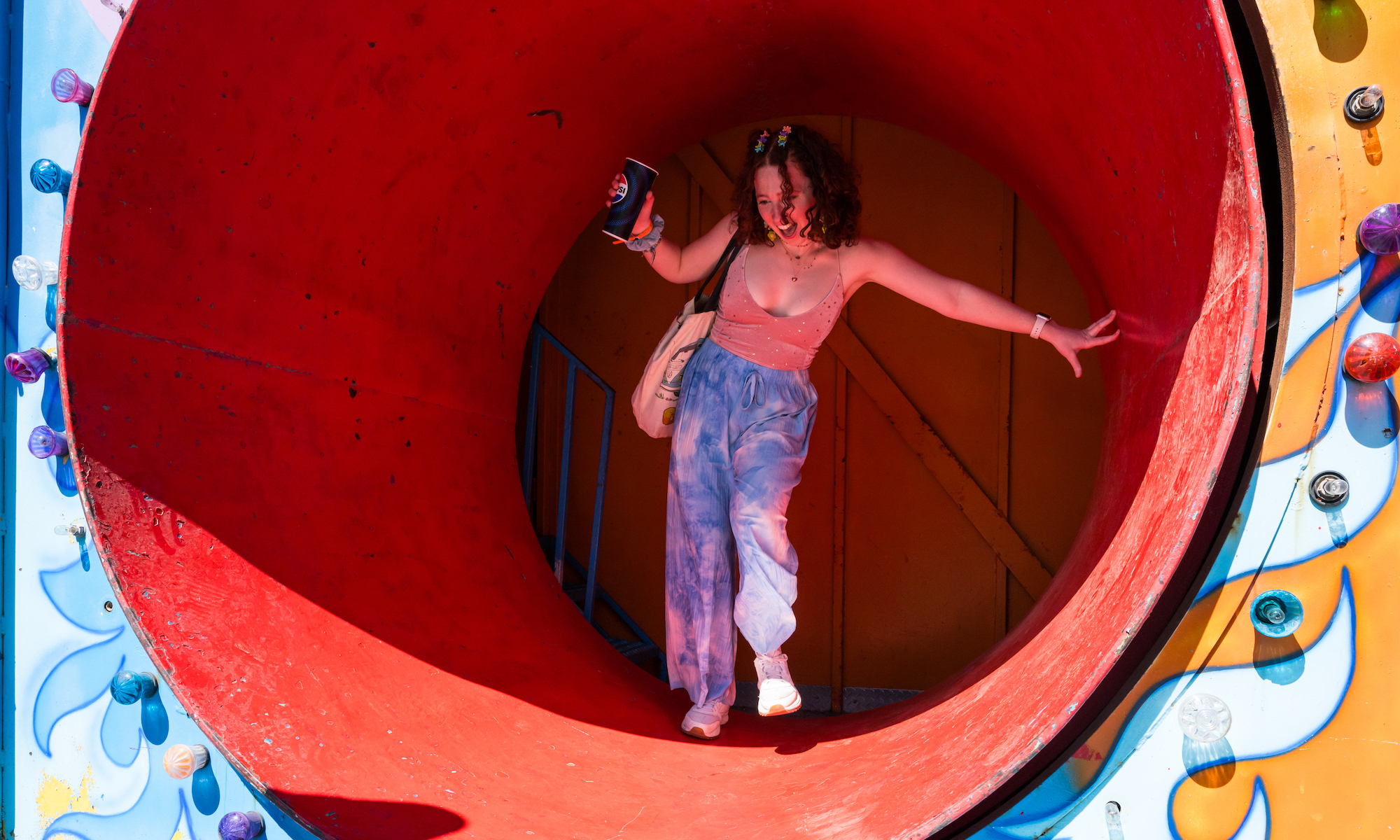 student emerges from rotating cylinder as part of a fun house