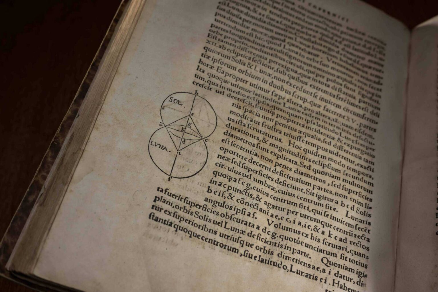 A page of <em>On the Revolutions of the Heavenly Spheres</em> that shows a old mathematical drawing and latin text.