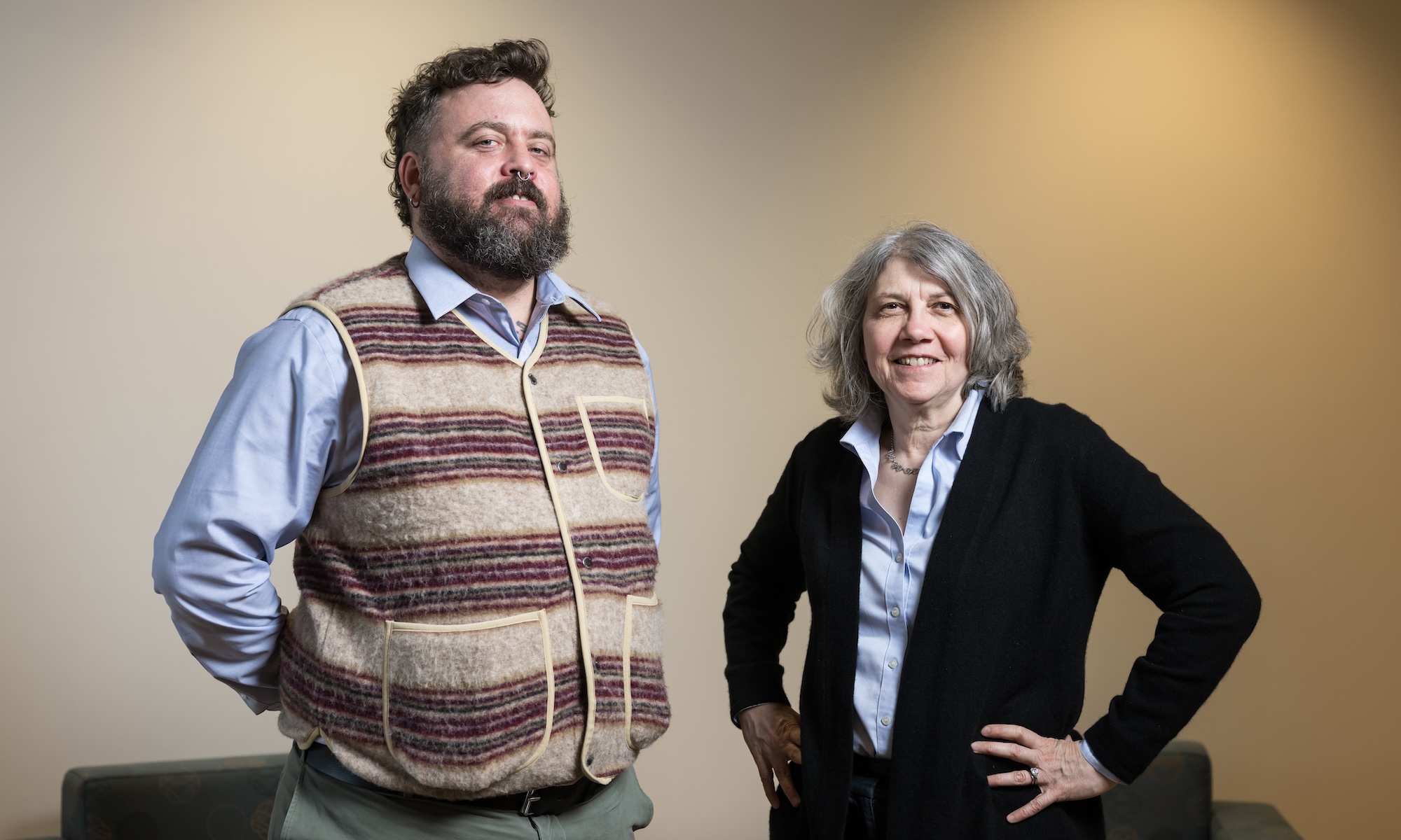 Feature image Peter Christensen and Lainie Ross standing next to each other against lit wall.