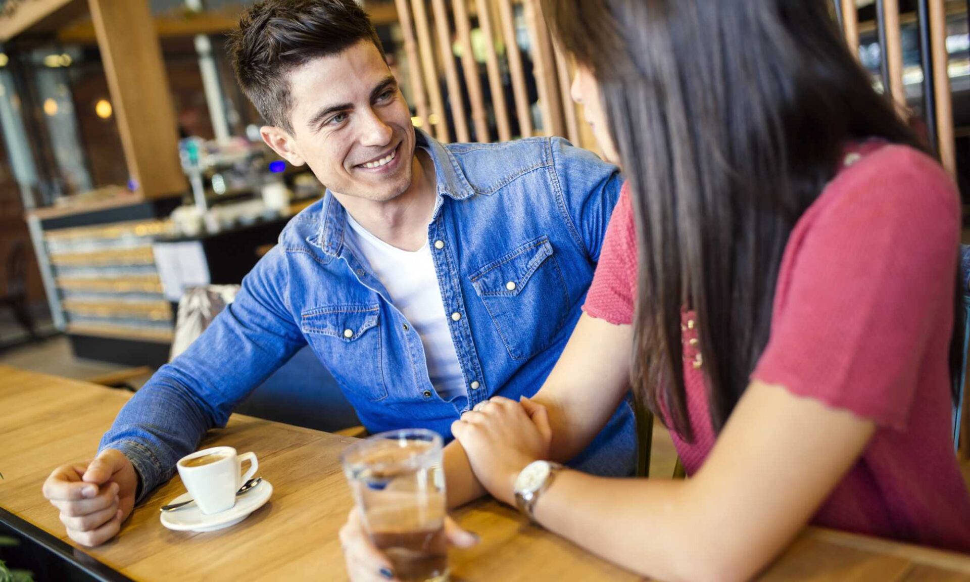 Happy young couple flirting in a restaurant with drinks.