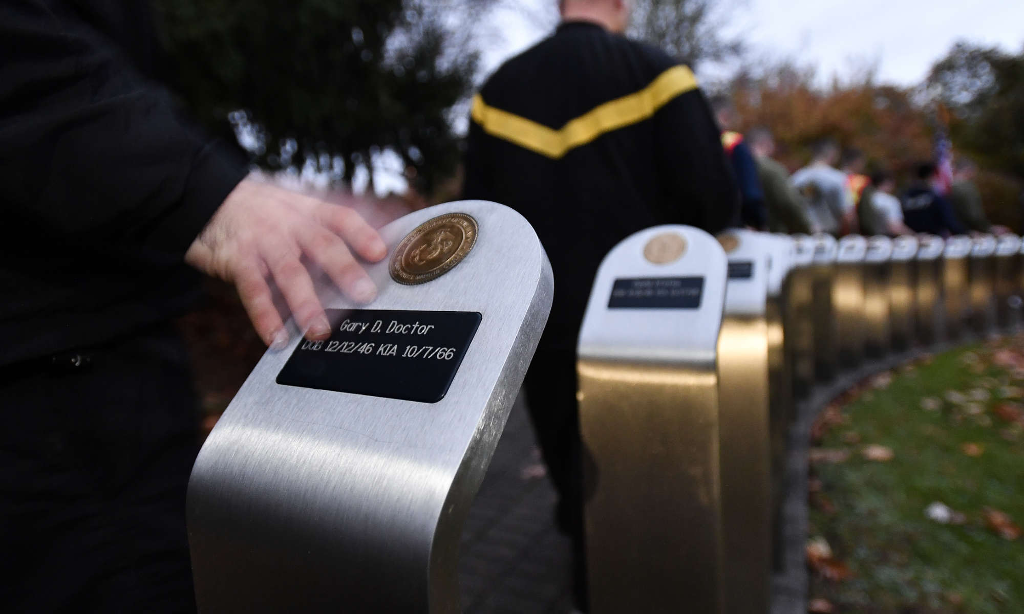 Close up of NROTC cadets walking by and touching the Vietnam Veterans Memorial at Highland Park in the city of Rochester.