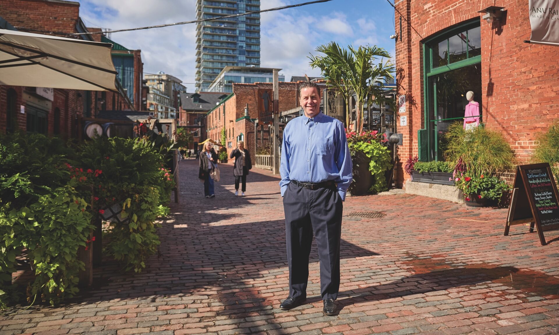 Jeffrey Kishner in blue button-down standing in the Distillery District of Toronto.