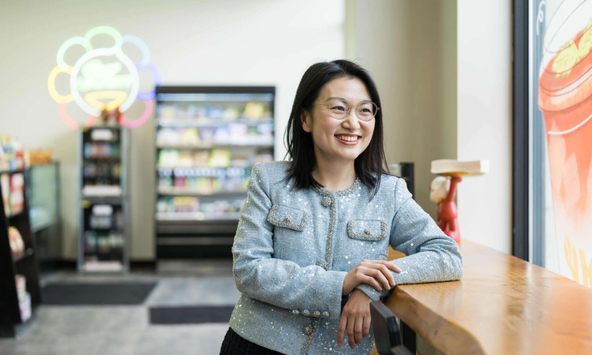 Yaofang (Vicki) Liang smiles and looks out the window of JoyMart, the Asian grocery store and cafe she founded and runs.