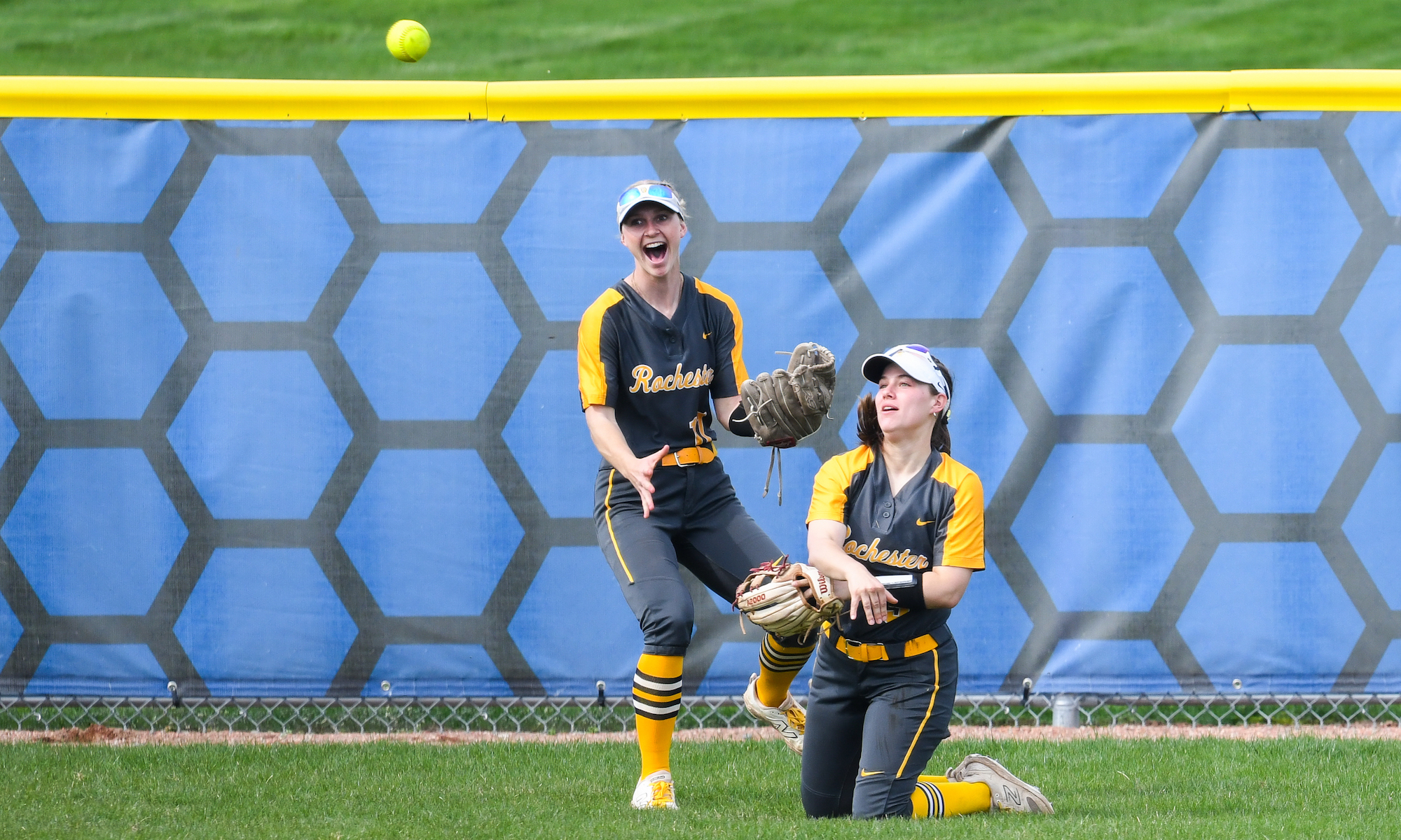 Sara Mazur throws to the infield after making a diving catch as teammate Jensen Sminchak reacts.