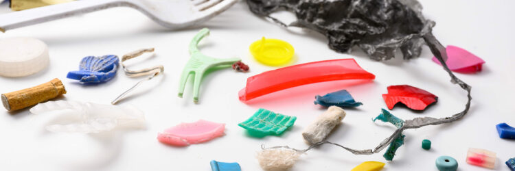 An array of plastics and microplastics, from utensils to cigarette butts, against a white background.