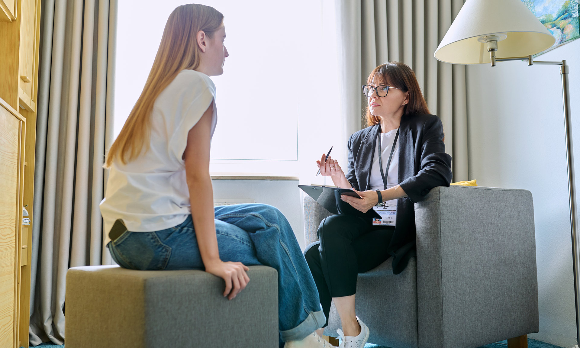 A therapist speaks with a teenaged girl.