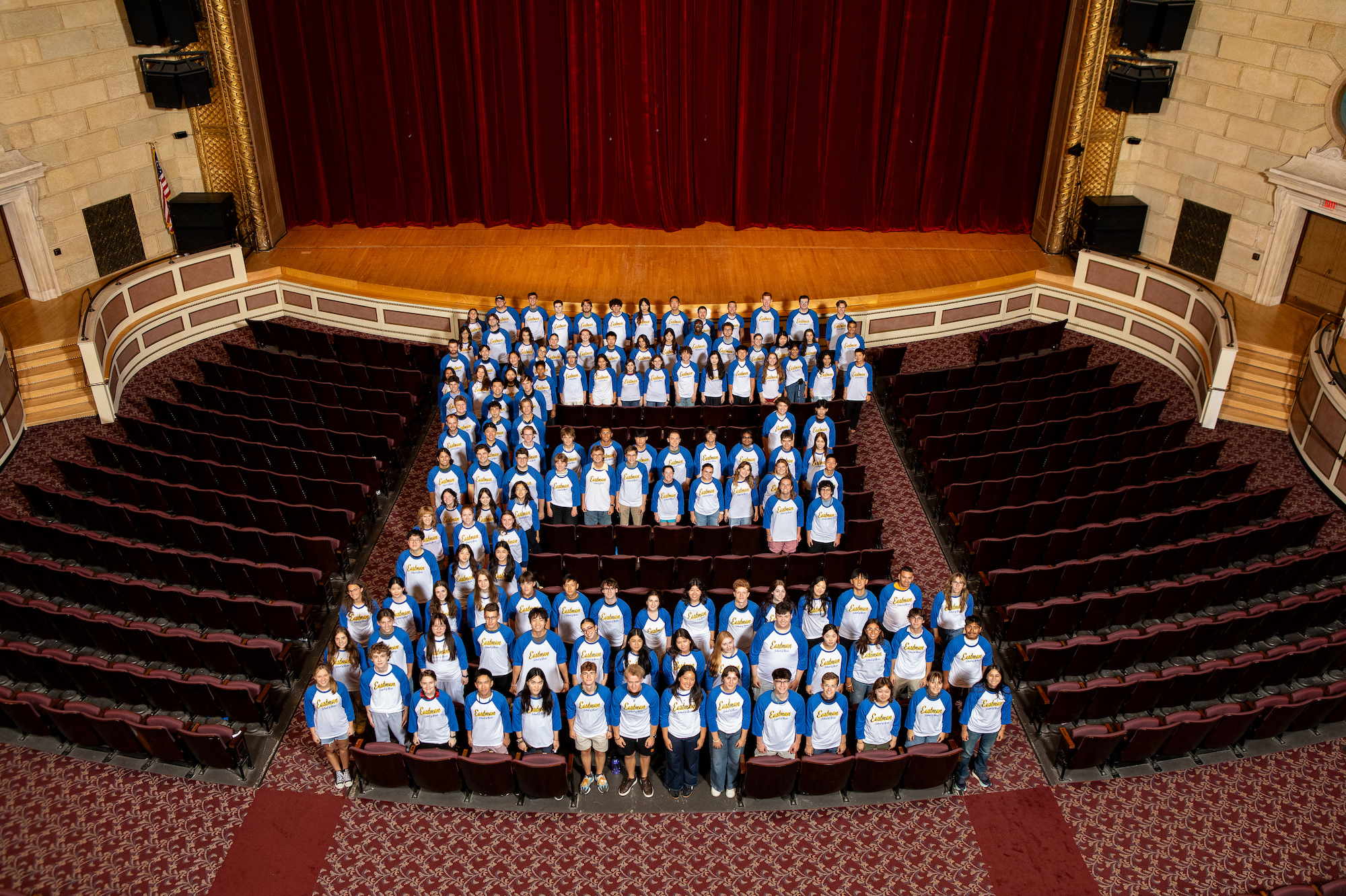Class of 2029 students at the Eastman School of Music pose in the shape of the letter E. 