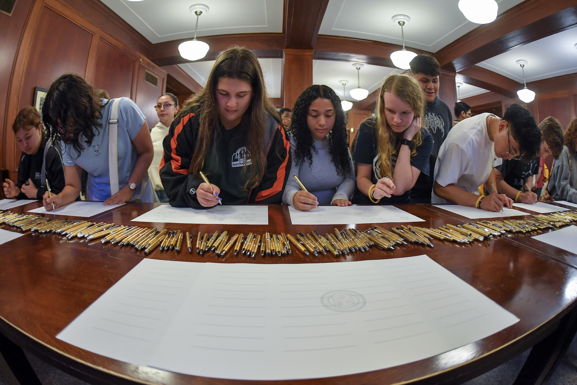 Students sign the class roll. 