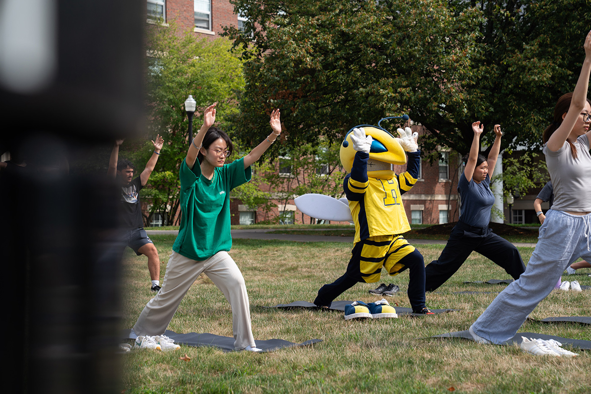 Students and Rocky do yoga on the quad. 