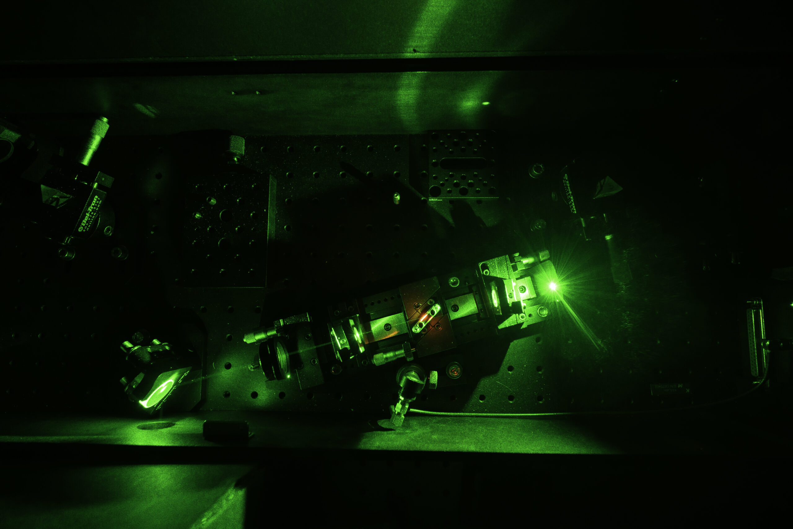 A laser oscillator bathed in green and black shadows.