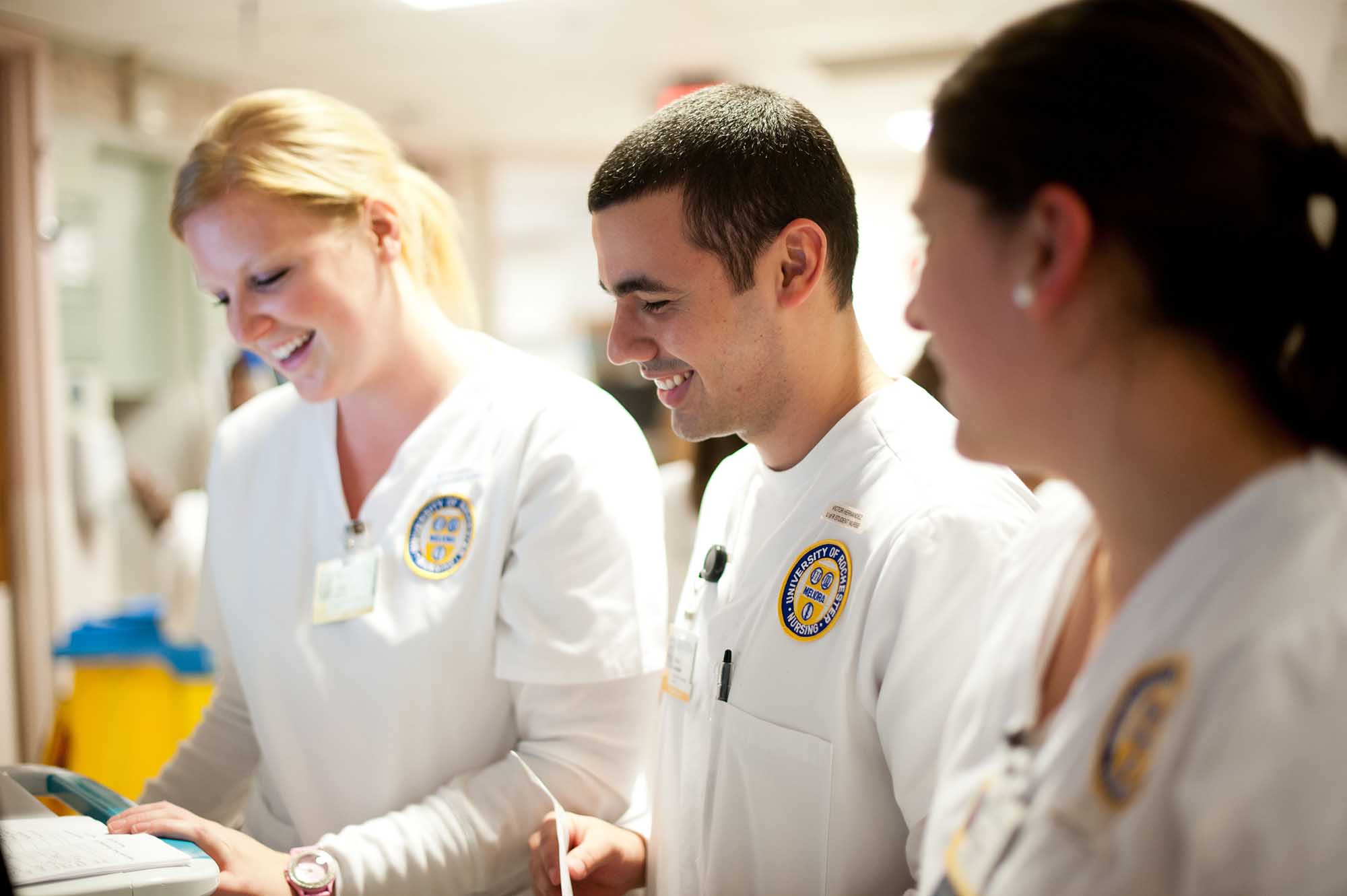 A trio of nursing students looks over a patient file.