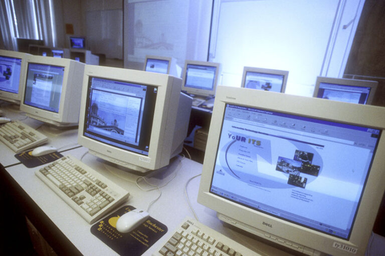Rows of desktop computers featuring screens that say 