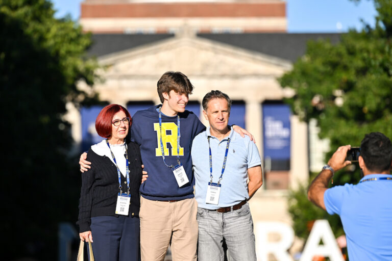 Attendees pose for photos near Meliora letters.