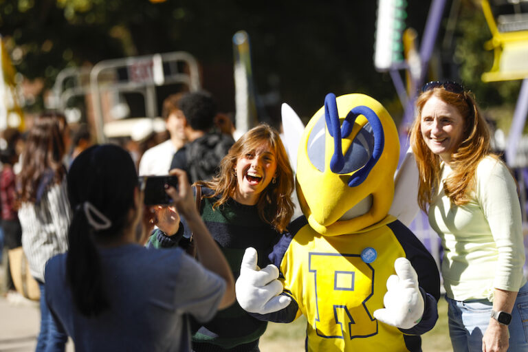 People pose with Rocky, the University of Rochester mascot.