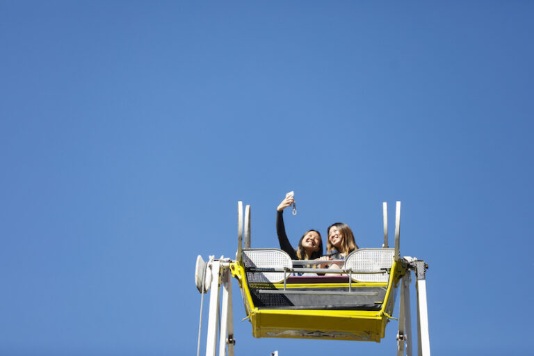 Two people take a selfie atop the Ferris wheel.