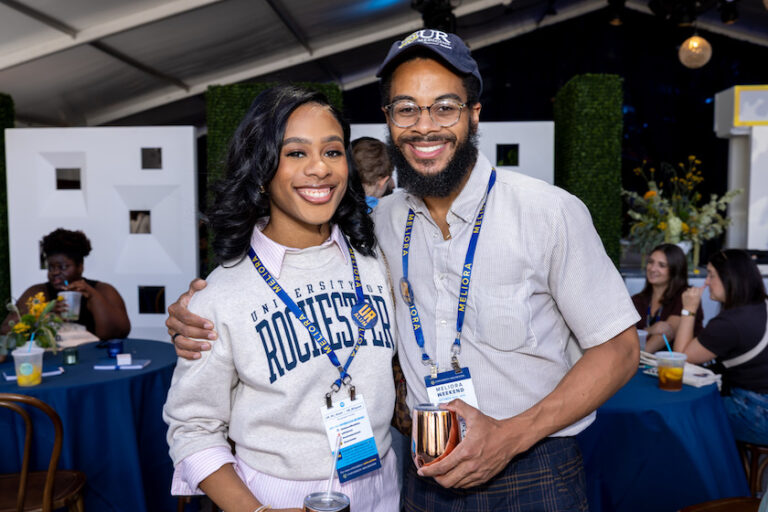 Two people pose in Meliora Village.