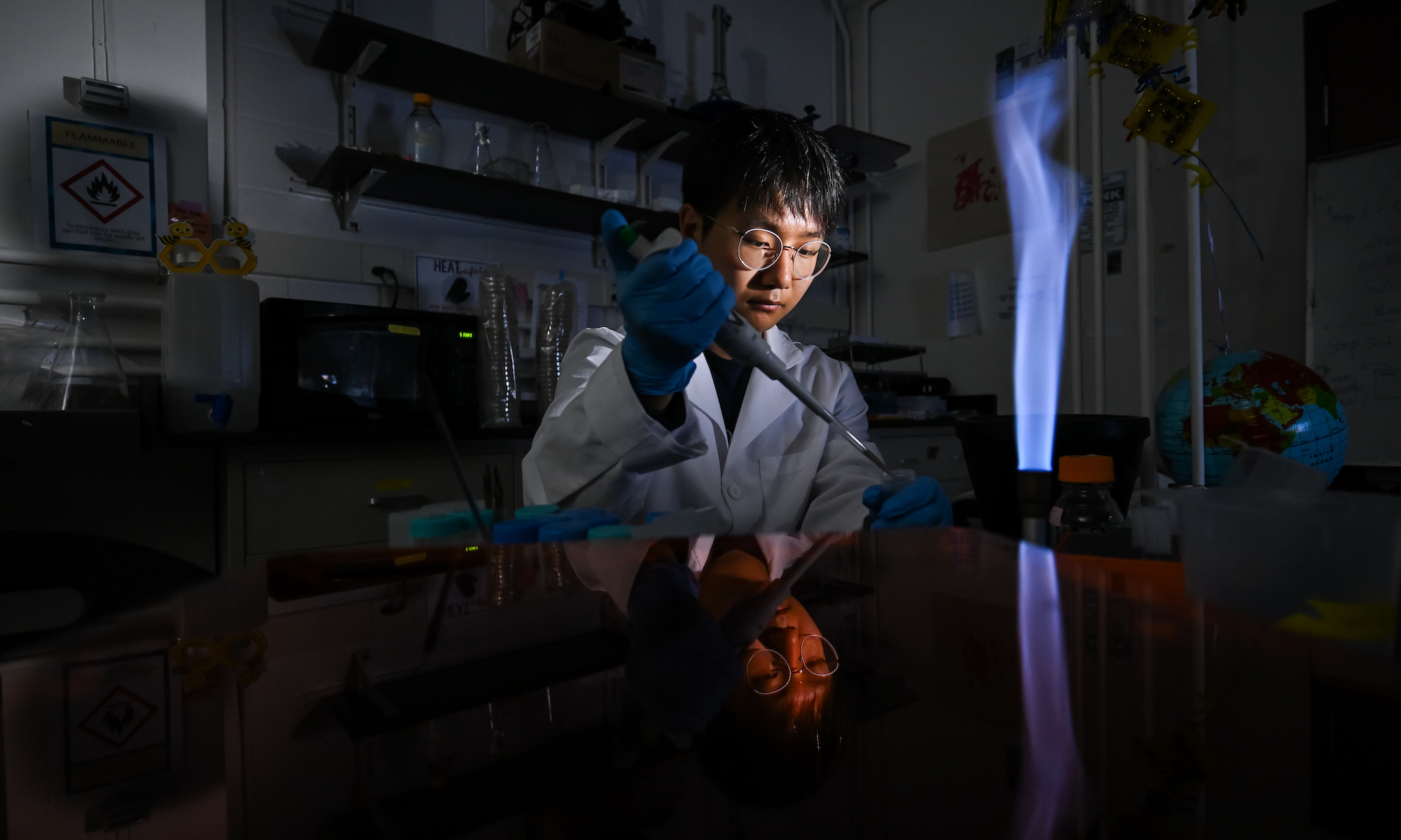 A student in a lab uses a pipette.