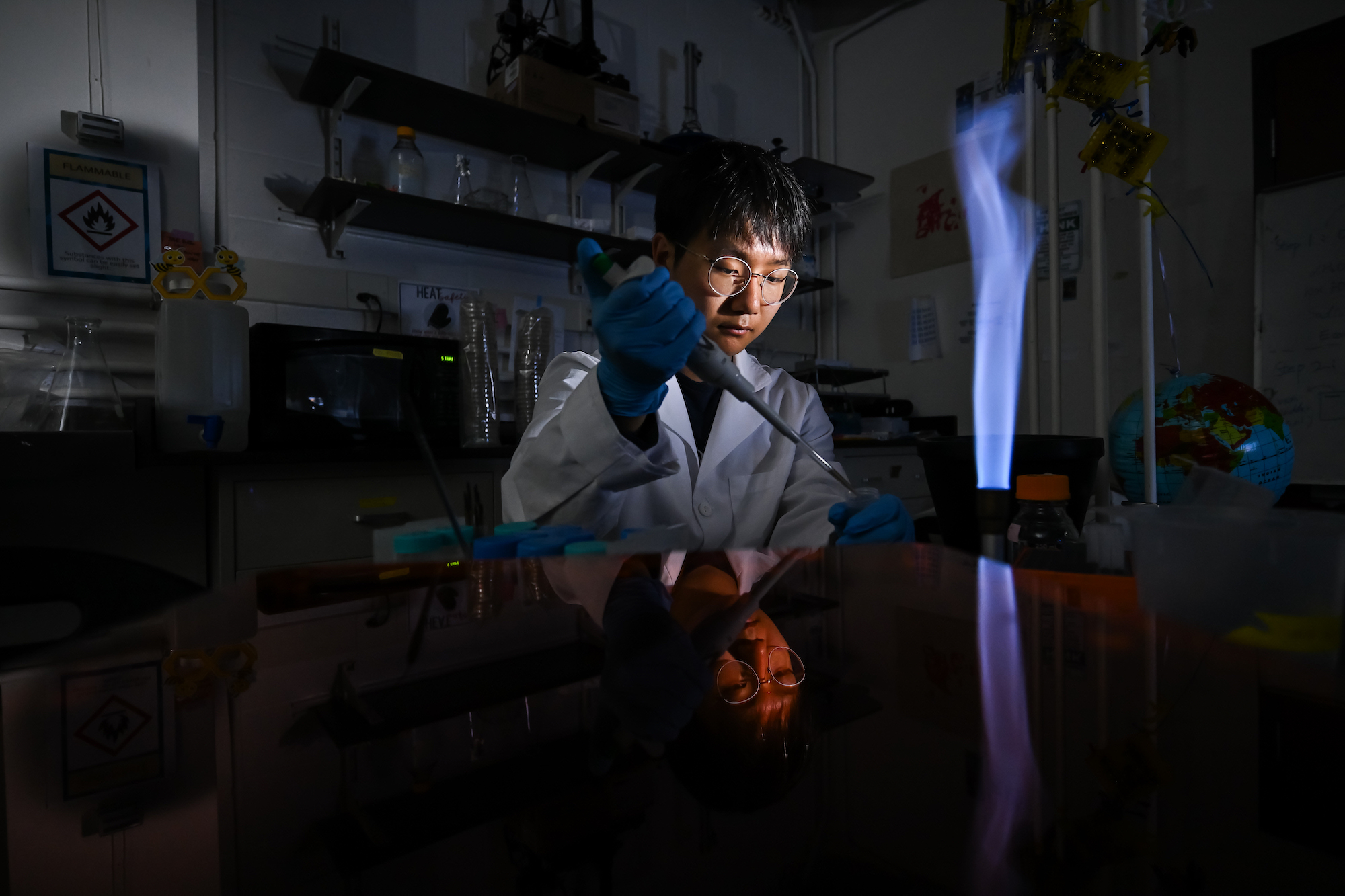 A student in a lab uses a pipette. 