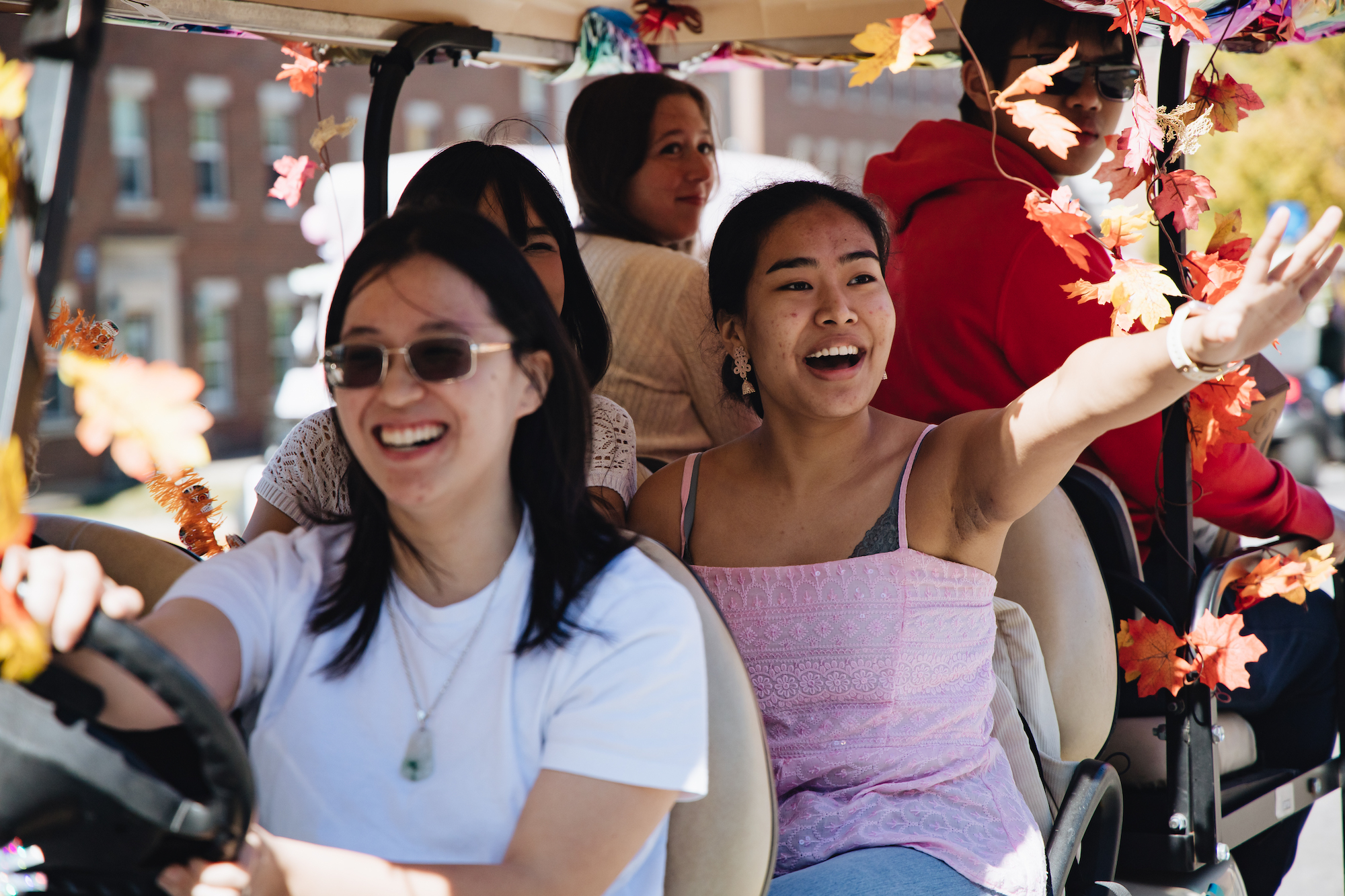 Students ride in a decorated golf cart. 