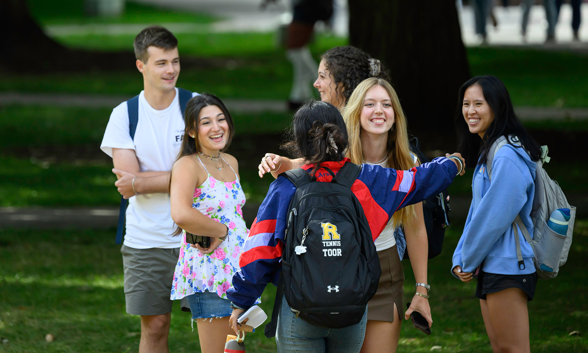 Group of URochester students on the Eastman Quad smiling and greeting each other on the first day of classes.