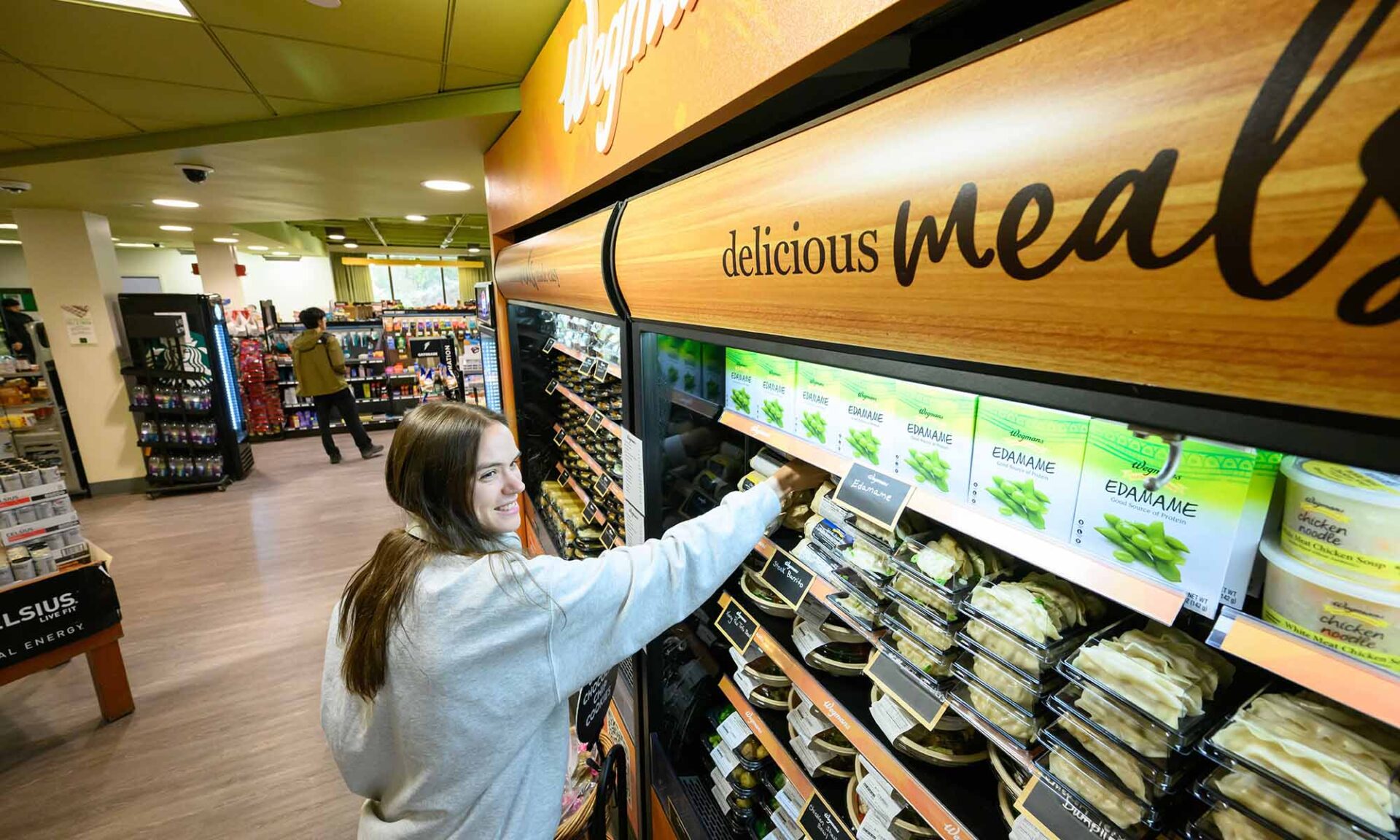 A URochester student grabs Wegmans products off the shelf on campus.