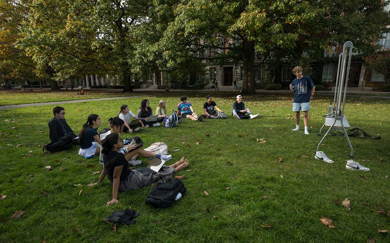 Group of URochester students enjoy class outside on the Eastman Quad on a nice fall day.