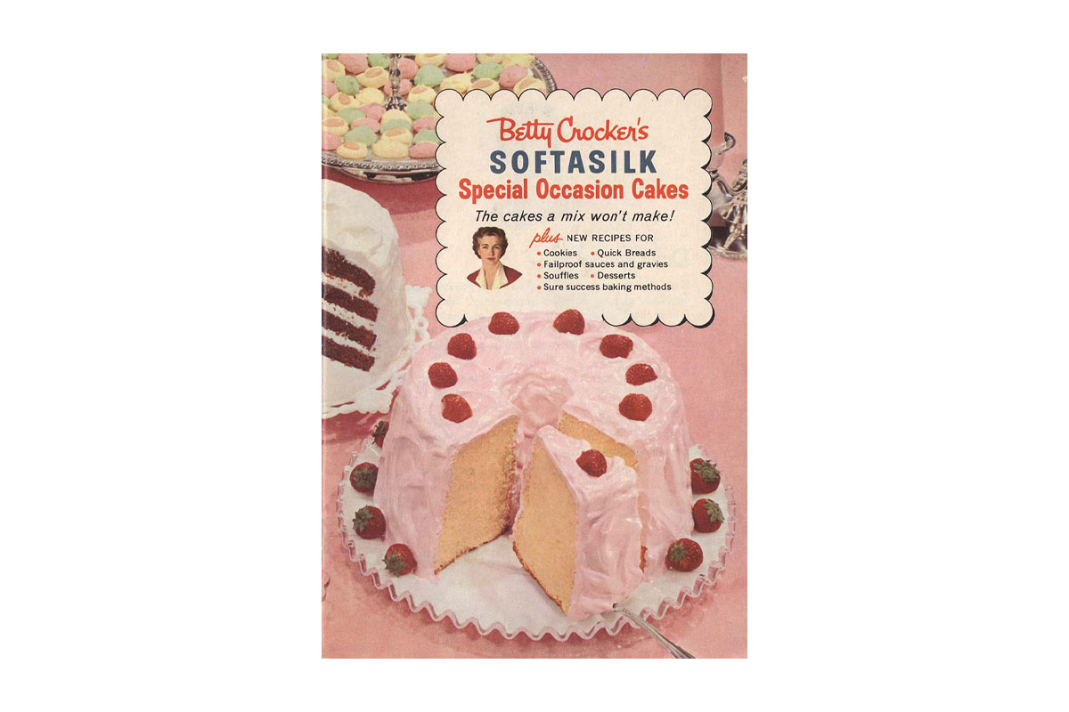 A vintage cookbook featuring a beautifully decorated cake on the cover, showcasing classic baking recipes.