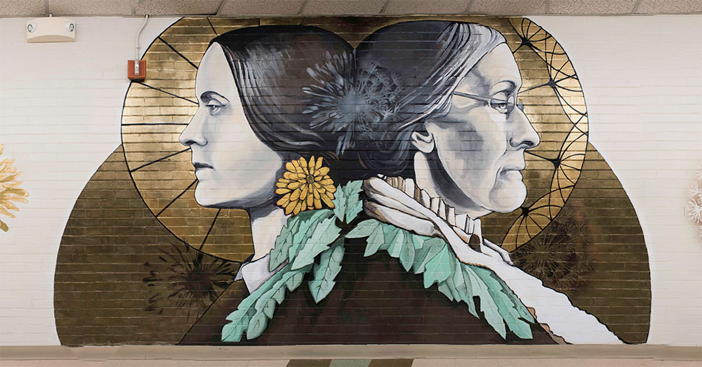 A vibrant mural depicting two women adorned with flowers, painted on a wall.