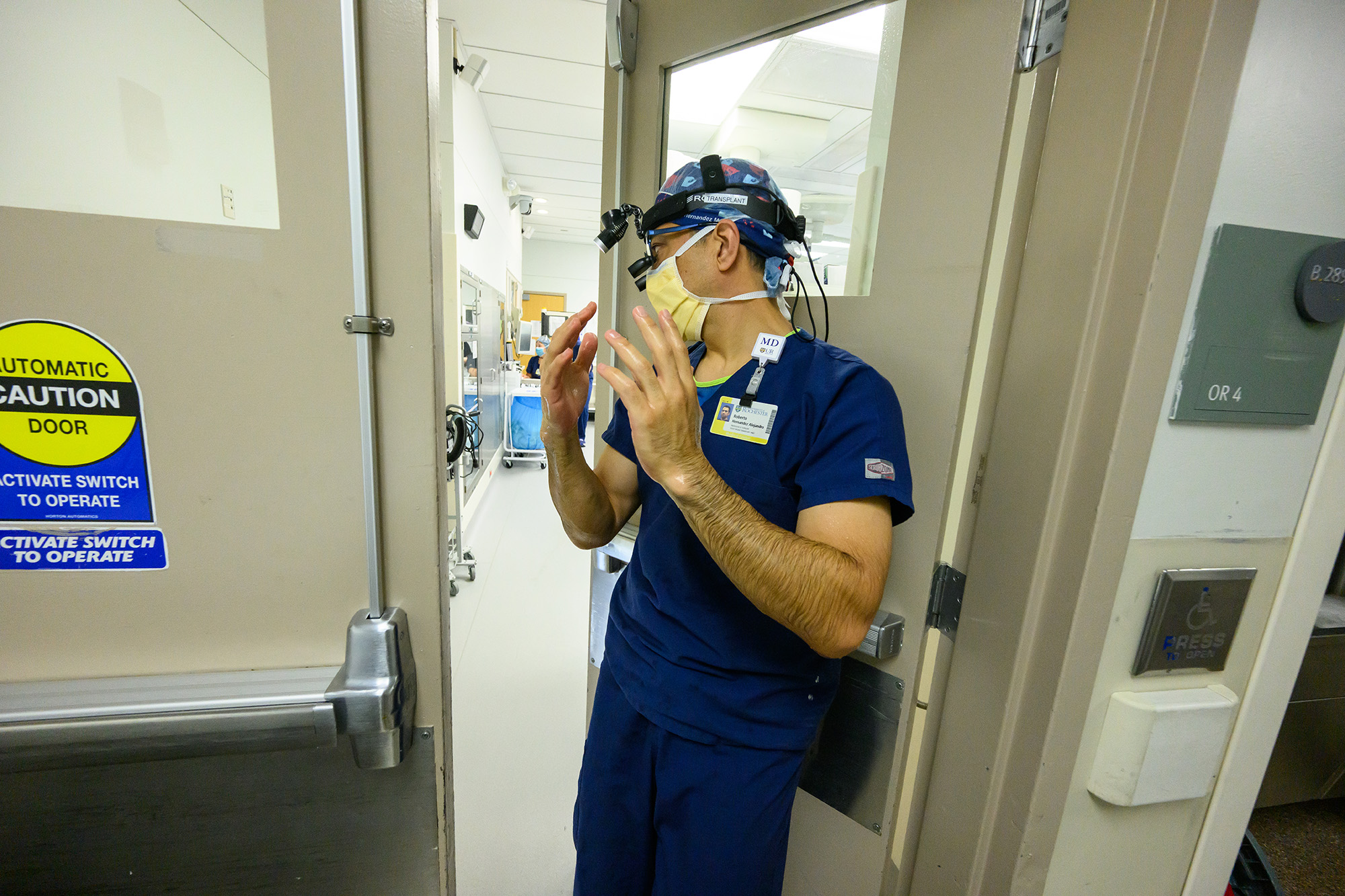 Dr. Roberto Hernandez-Alejandro enters an operating room with his hands sterilized for a living donor liver transplant surgery.