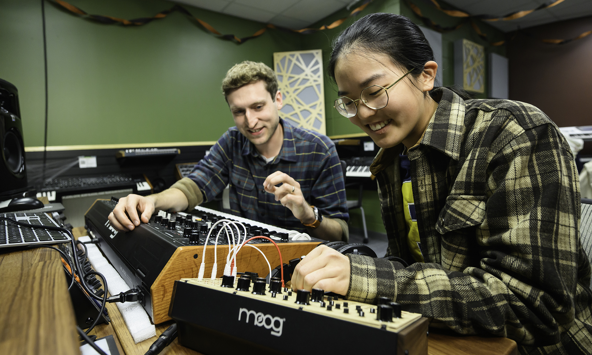 Rick Carl and Abby Che in front of a Moog Labyrinth synthesizer.