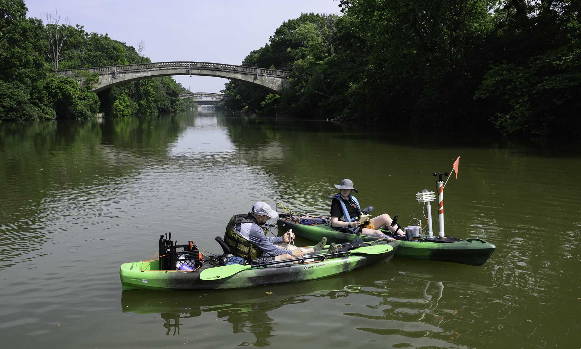 Two URochester researchers in souped-up kayaks gather samples where the Genesee River and Erie Canal converge.