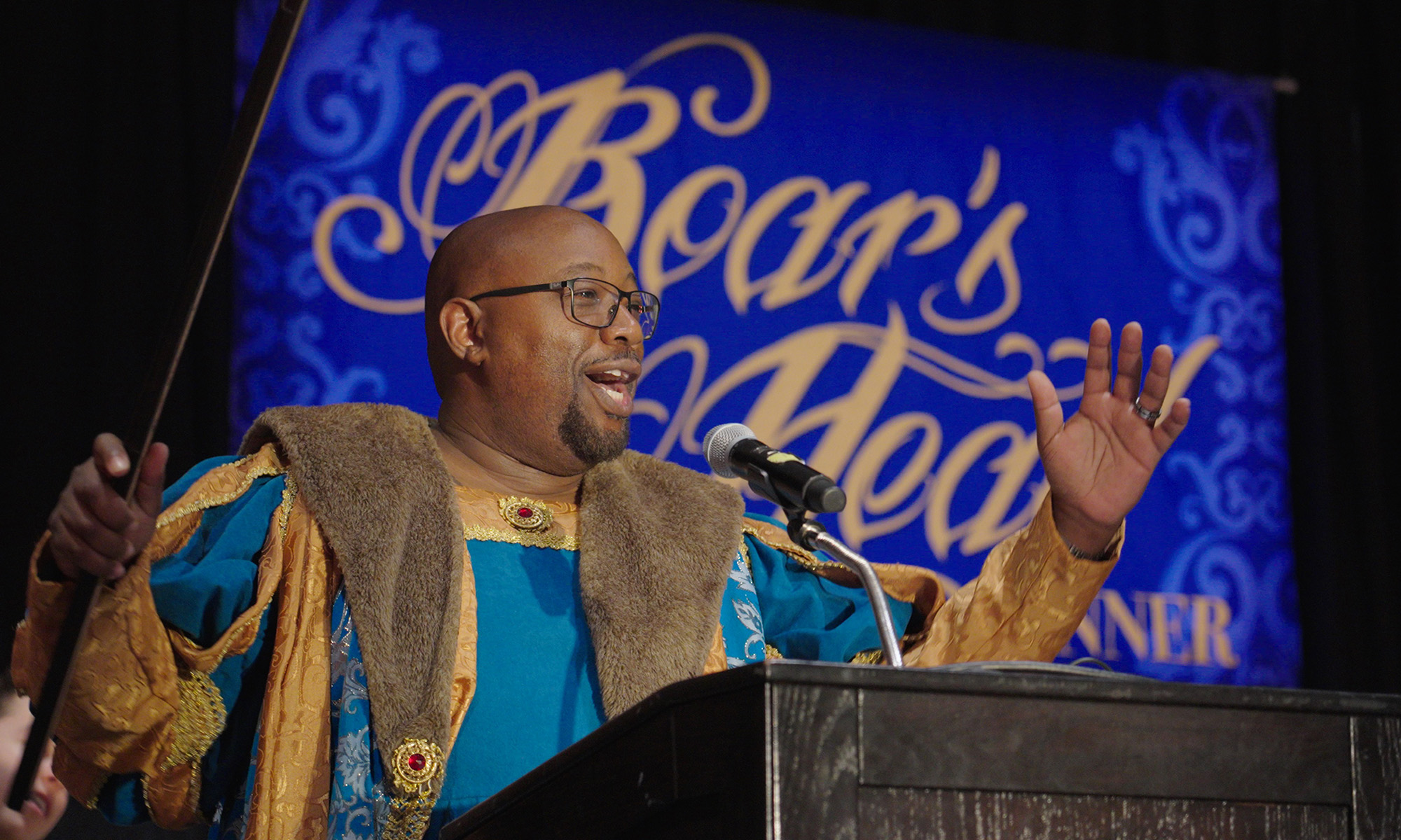 John Blackshear in medieval garb and at a podium during his inaugural Boar's Head Dinner.
