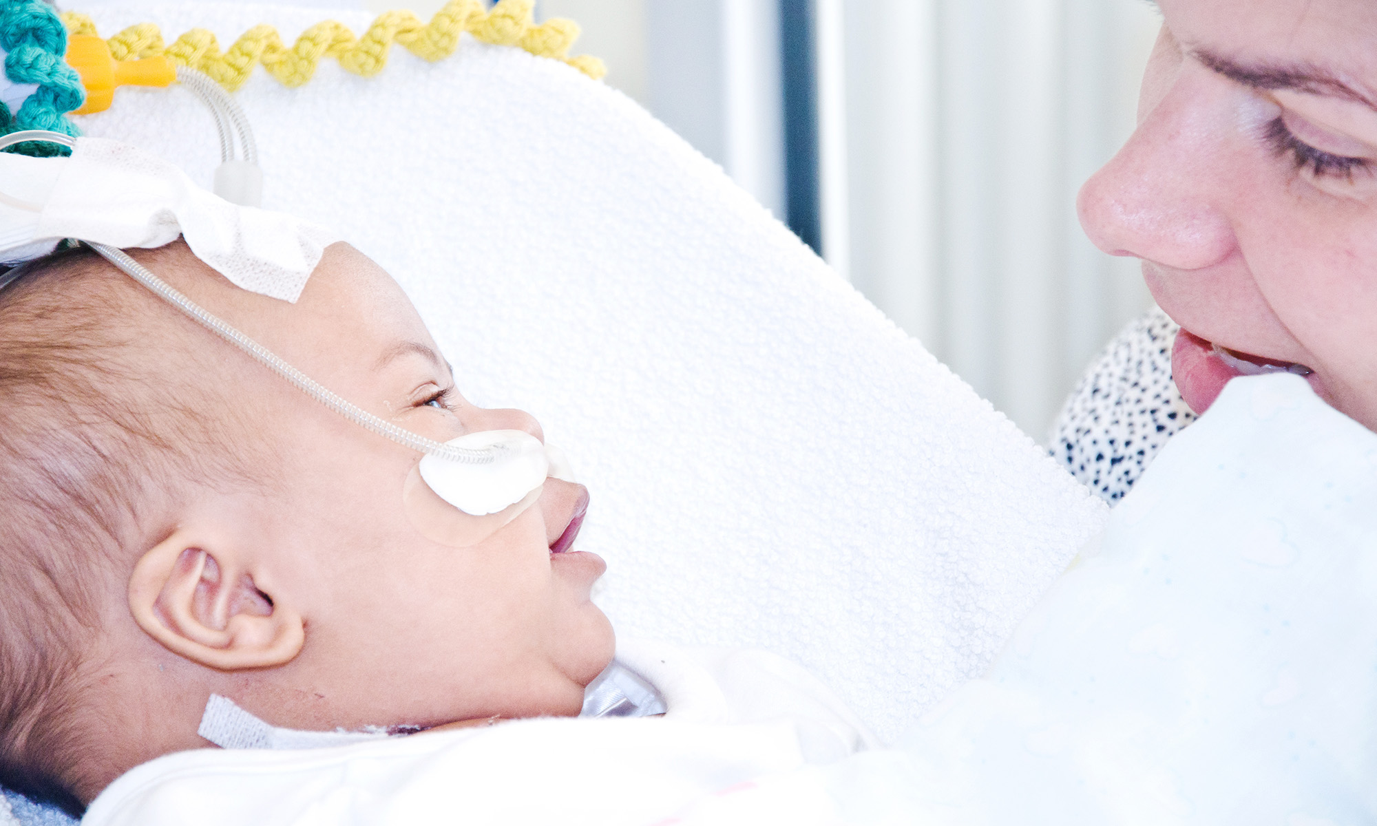 Close up image of a baby with oxygen support and mother nearby to illustrate respiratory syncytial virus, or RSV, in babies and infants.