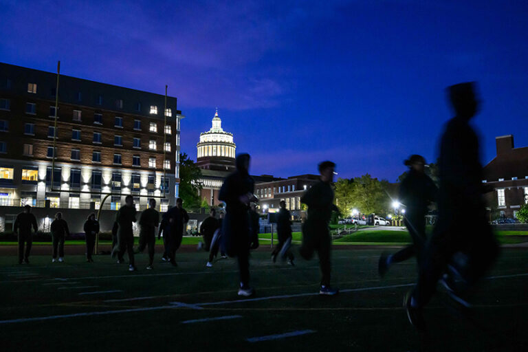 URochester NROTC students running sprints at dawn on campus.