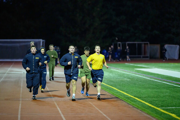 NROTC midshipmen run laps at Fauver Stadium.