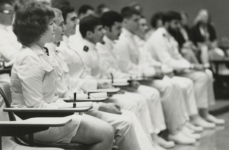 Black and white archival photo of URochester NROTC students sitting in class.