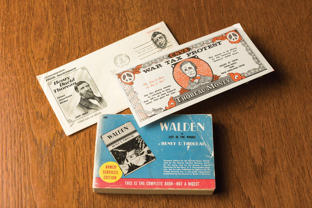 (bottom) “Walden, or, Life in the woods.” New York : Editions for the Armed Services, [between 1944 and 1947]. The government published pocket-sized paperback books for the soldiers to carry with them during World War Two. Though thousands were distributed, copies are scarce today because most were worn out or thrown away. It is probable that this was the largest printing of Thoreau’s book.(top) First day cover, U.S. postage stamp and envelope commemorating 150th anniversary of Thoreau’s birth, July 12, 1817.  The item was hand canceled on July 12, 1967 in Concord, MA.
(middle) “Thoreau Money” produced by Committee for Nonviolent Action, c. 1960’s. Distribution of Thoreau money was a hallmark during antiwar protests, serving as a concise way to explain the theory and practice of war tax resistance.  Two versions of “War Tax Protest” Thoreau Money were issued, this is an example of the earliest, with the image of Thoreau probably derived from the 1856 daguerreotype by Henry David Maxham.  The note was designed by by Mark Morris, an artist associated with CNVA-West, and printed at Grindstone Press in New London, CT. // Materials from The Raymond R. Borst Collection of Henry David Thoreau in the University of Rochester's Department of Rare Books, Special Collections and Preservation are pictured June 12, 2017.  // photo by J. Adam Fenster / University of Rochester