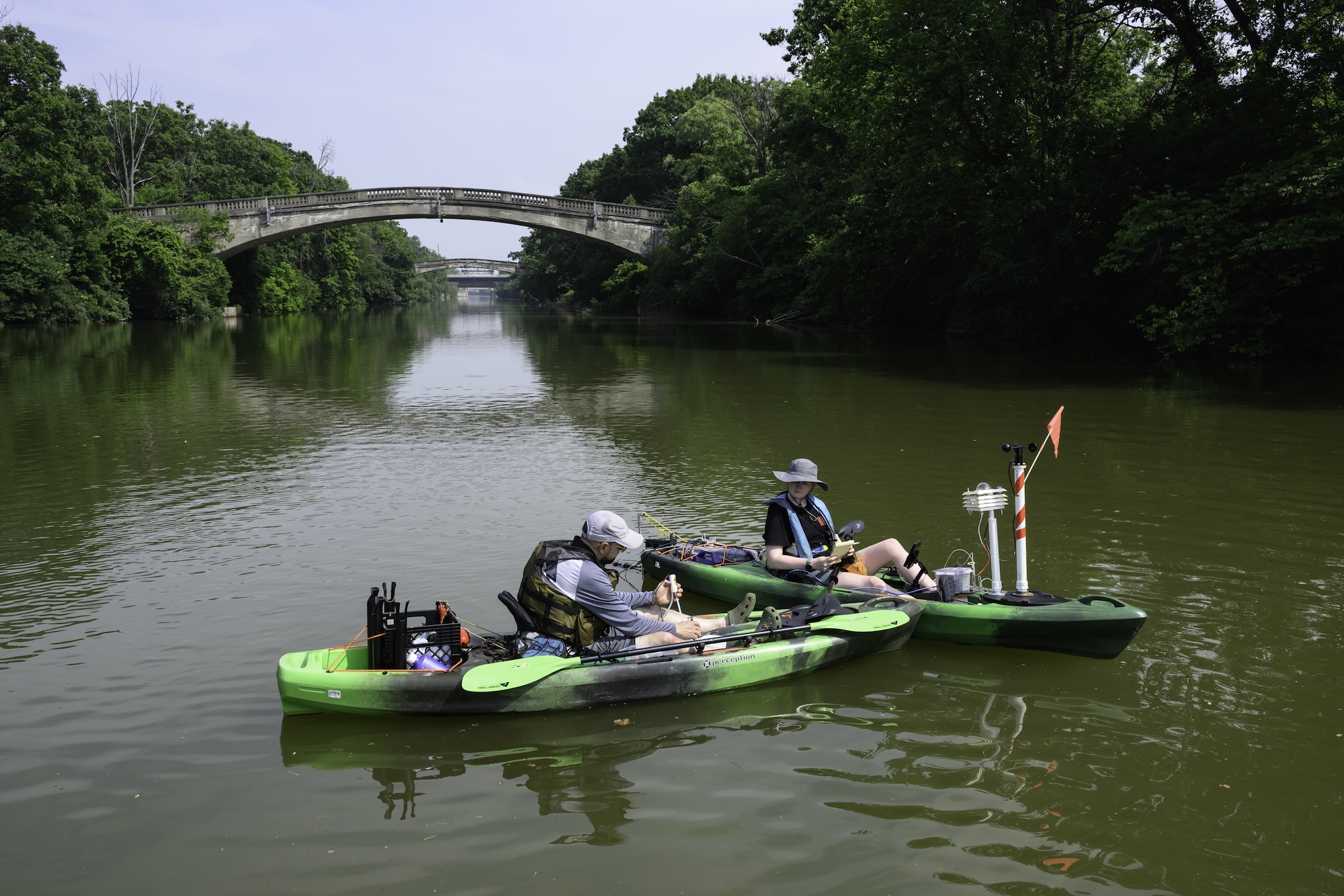 Scientists on kayaks gather samples from the Genesee River. 
