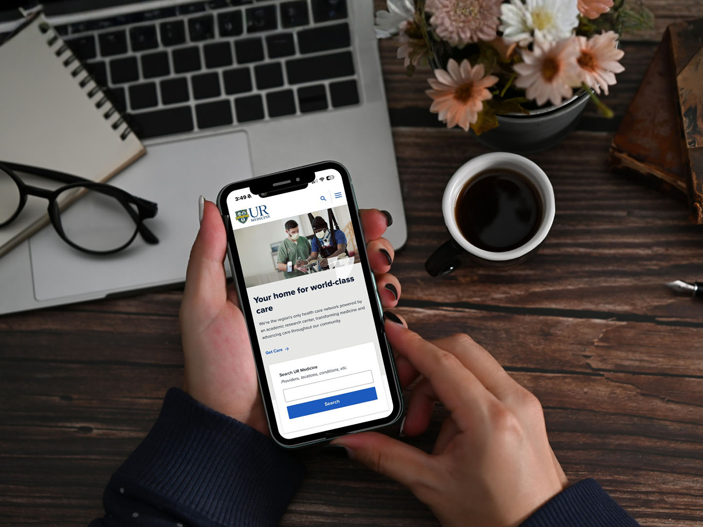 Hands holding a phone searching on the UR Medicine website.