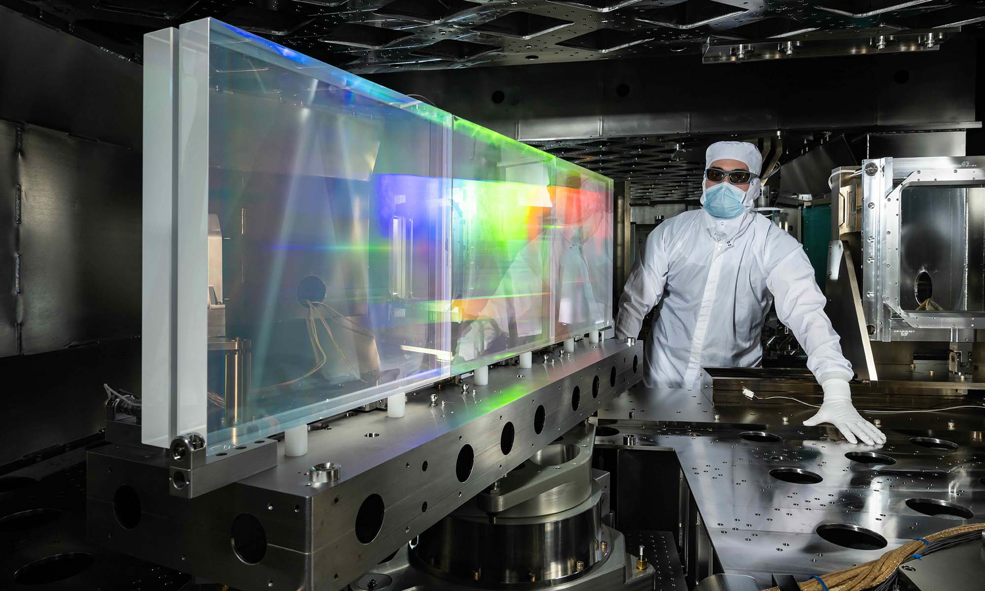 Person in a "bunny suit" of lab gear with equipment in the Grating Compressor Chamber of the OMEGA EP Laser.