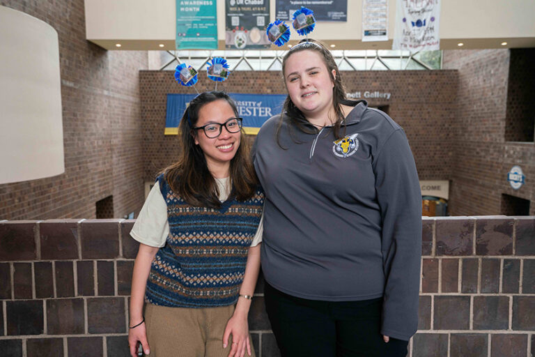Two University of Rochester students smile for the camera in Wilson Commons during the 50th anniversary celebration.