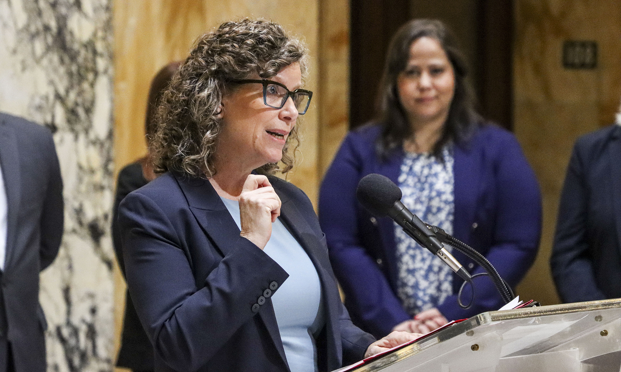 Jennie Noll speaks at a podium.