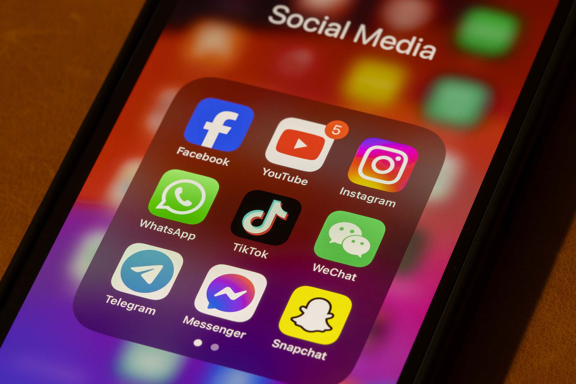 Close up of a smartphone showing the icons for top social media platforms. 
