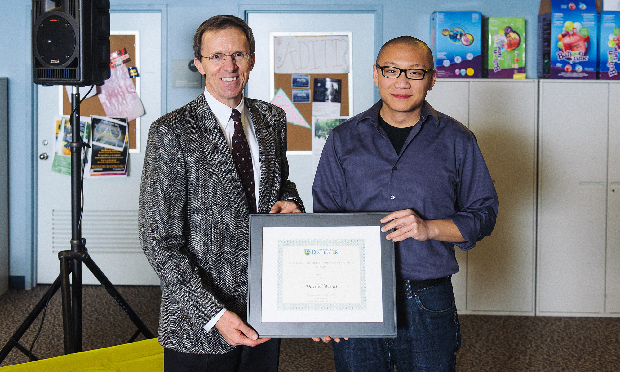 Larry Arbeiter and Dan Wang stand side by side and both hold a