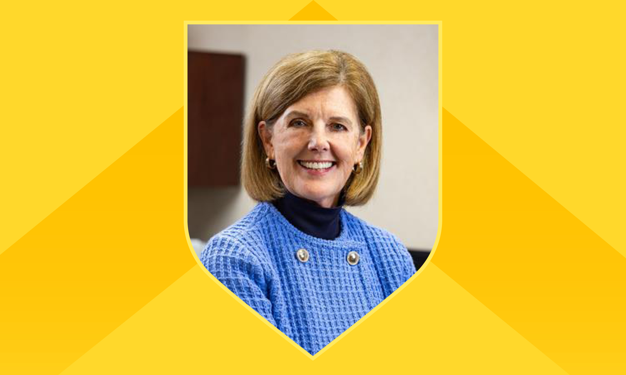 Portrait of Kathy Parrinello within a shield outline against a yellow background with a darker yellow chevron on it.