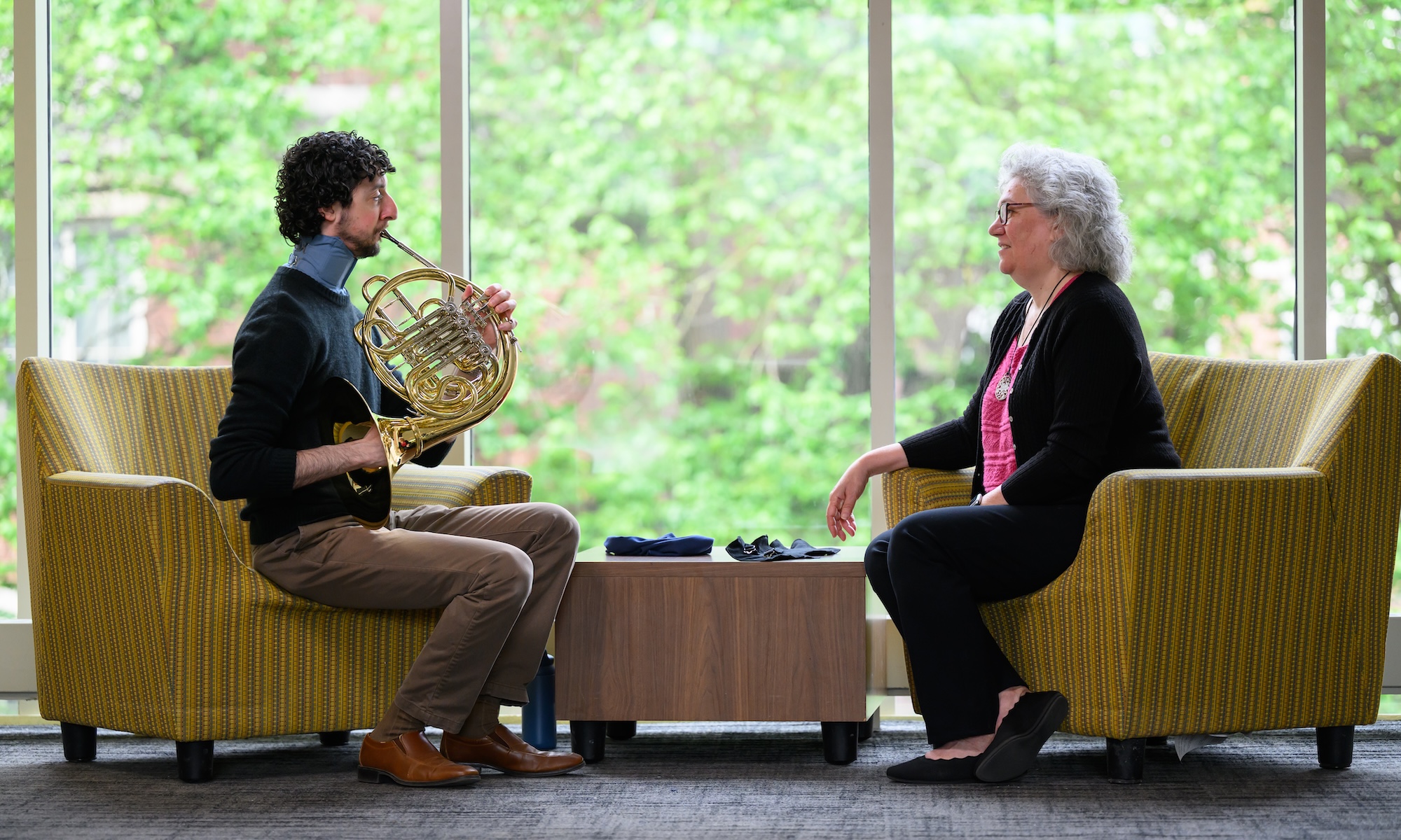 Jacob Factor plays the French horn across from Amy Lerner while wearing a custom neck brace to treat pharyngoceles.