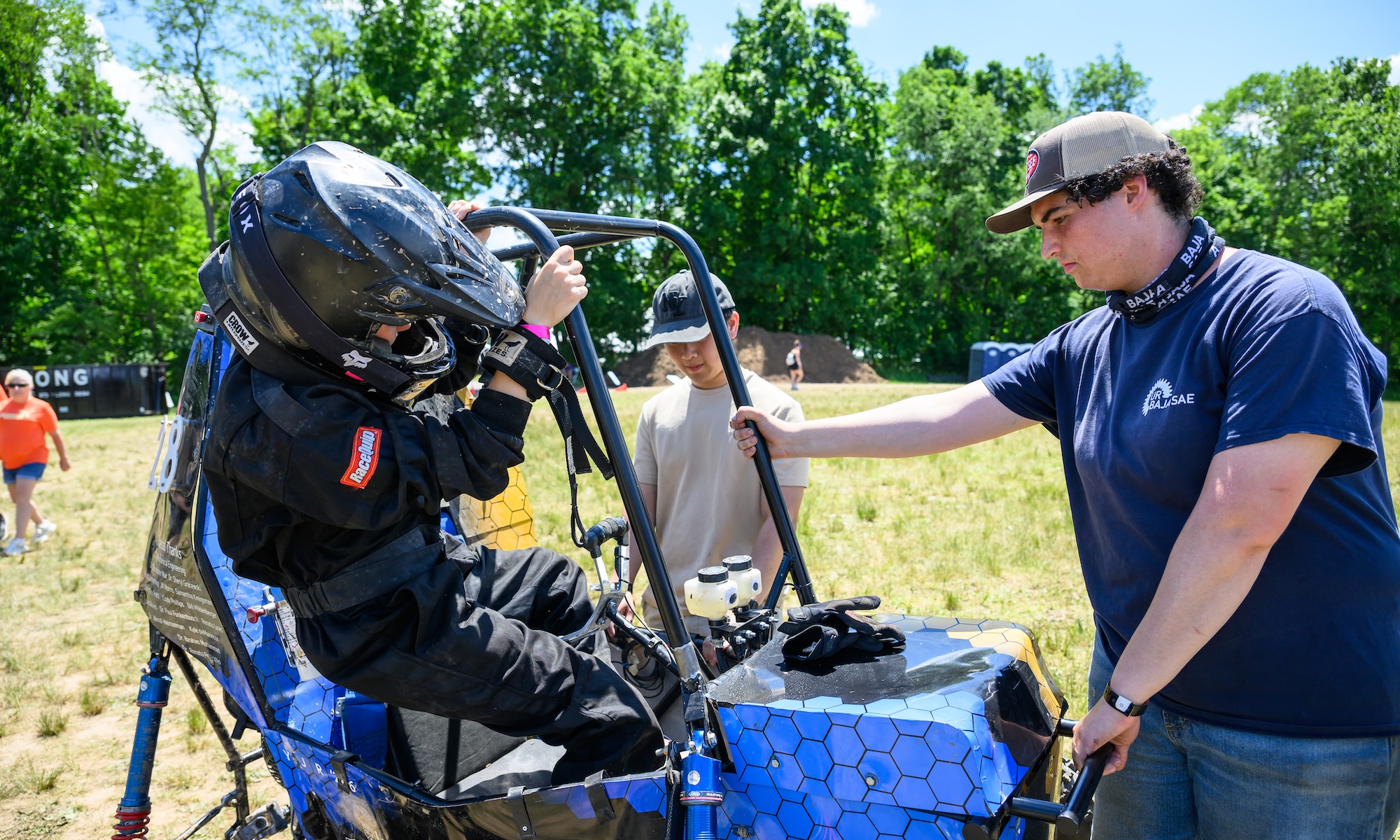 Two URochester students get situated within an off-road vehicle.