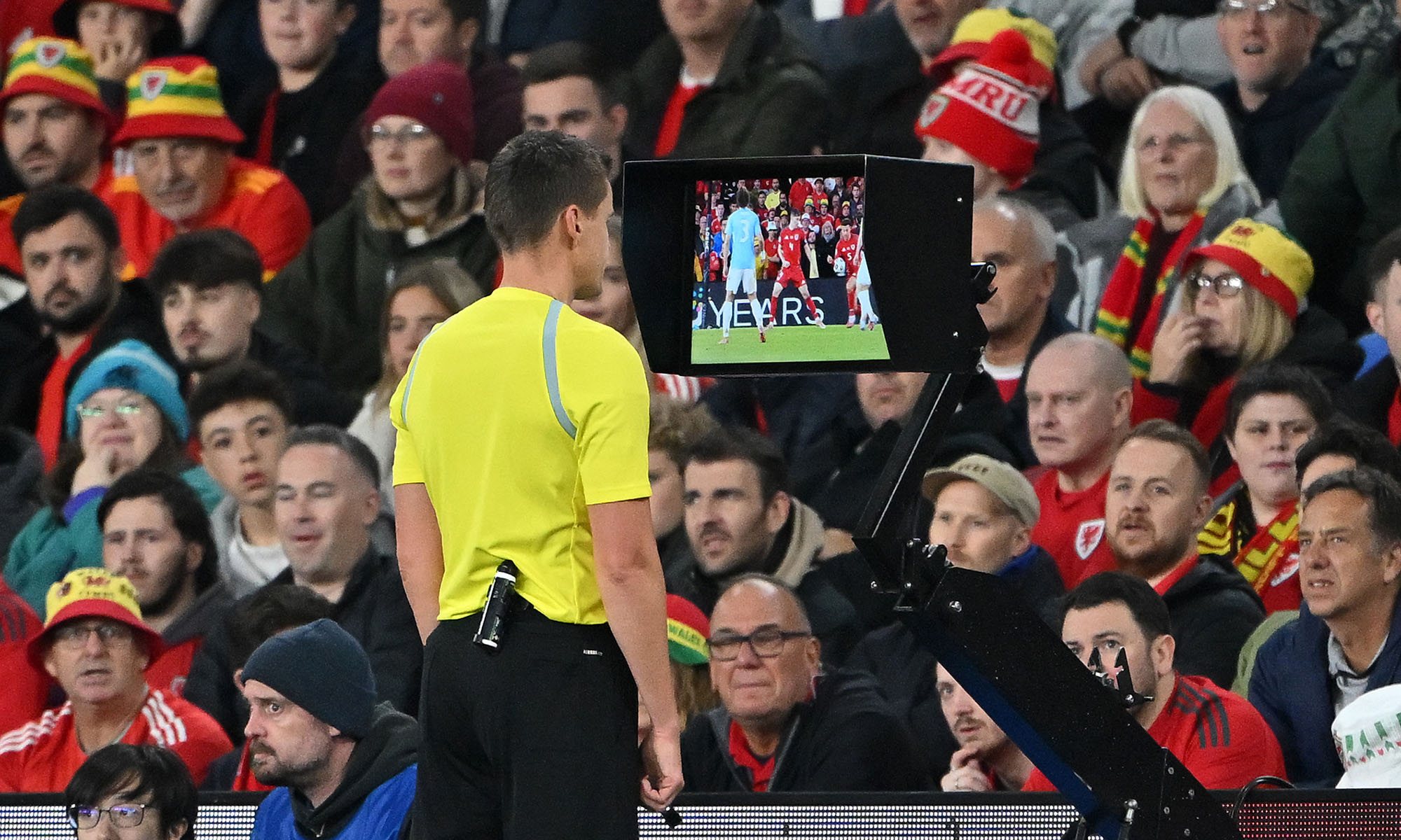 Referee Daniel Siebert checks the pitchside VAR screen.