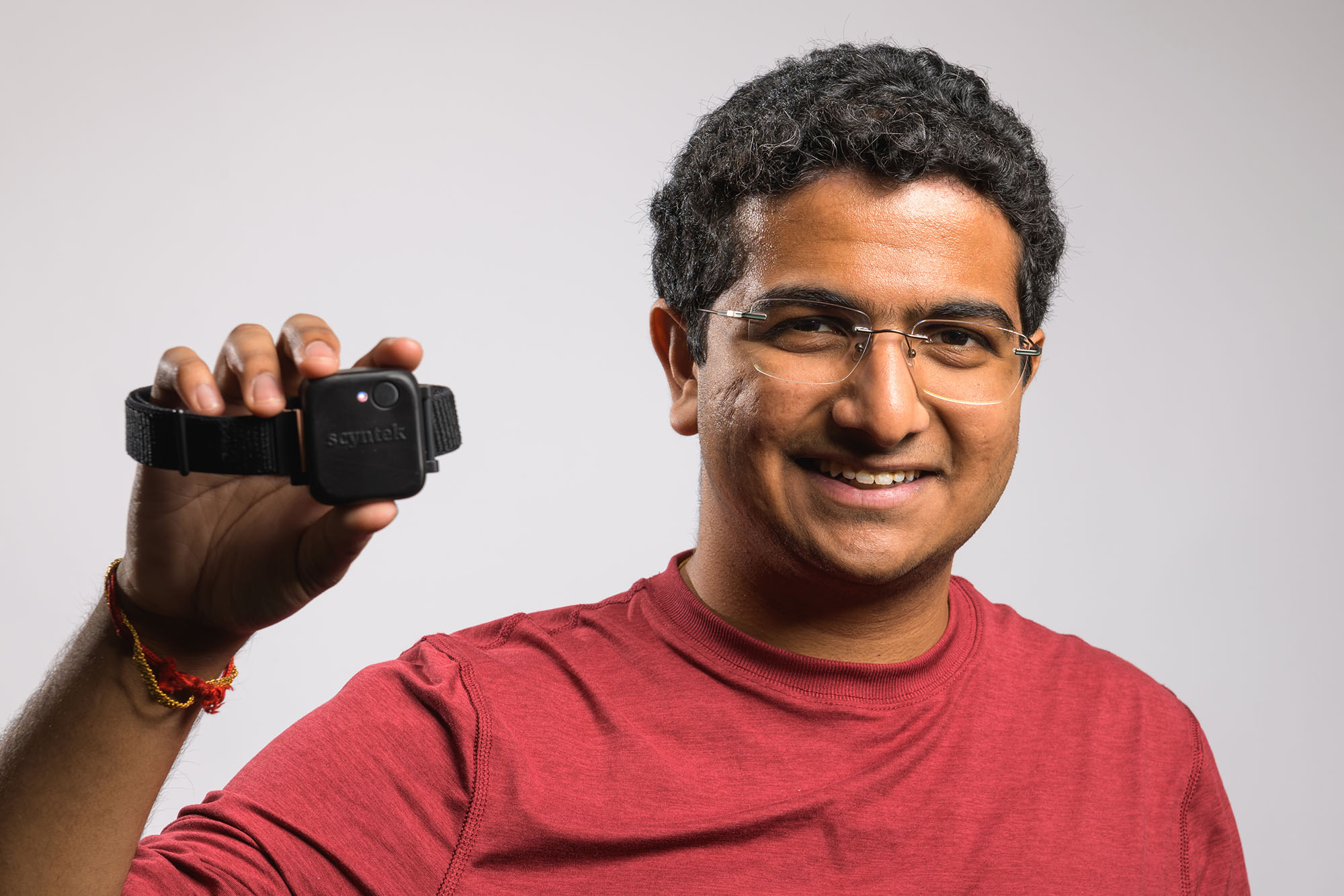 Student entrepreneur Karthik Ramakrishnan holding the device he developed to measure blood flow in the leg to detect clots.