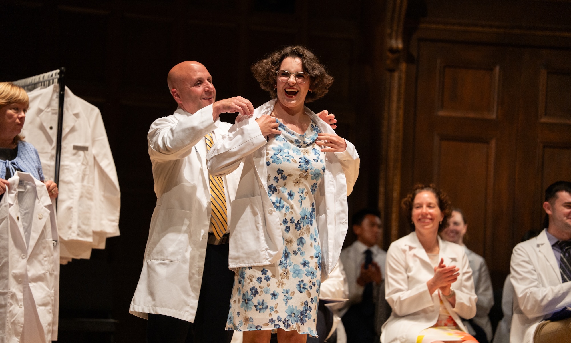 A member of the Class of 2030 receives a white coat during the White Coat Ceremony.
